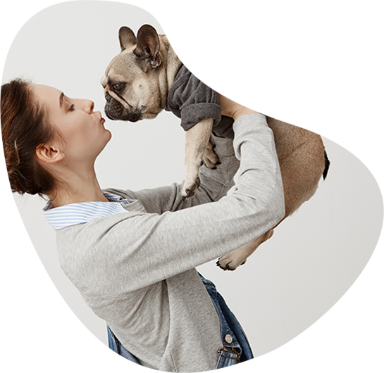 Mujer sostiene en brazos un Bulldog francés para dar un beso